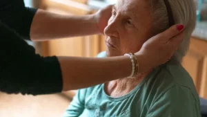 Beatmungsgerät, Absauggerät und Verbrauchsmaterial am Pflegebett eines Patienten mit Tracheostoma zu Hause