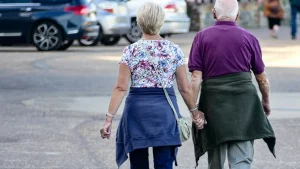 Beatmungsgerät am Pflegebett, daneben eine Pflegefachkraft mit Dokumentationsmappe