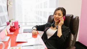 Frau telefoniert am Schreibtisch und organisiert von zu Hause aus