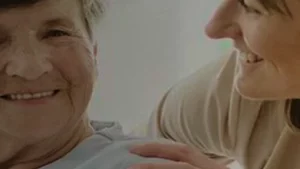 Ärztin füllt am Küchentisch eines Patienten die Verordnung für spezialisierte ambulante Palliativversorgung aus