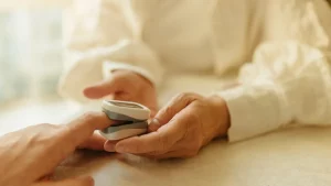 Älterer Mensch misst zu Hause die Sauerstoffsättigung mit einem Pulsoxymeter
