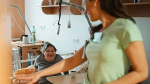 Pflegefachkraft wechselt die Trachealkanüle eines Patienten zu Hause