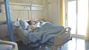 Therapeutin arbeitet in der neurologischen Frührehabilitation mit einem Patienten im Bett