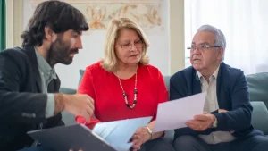 Tochter hilft ihrem Vater zu Hause bei Unterlagen zur Rentenversicherung